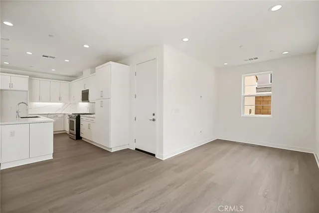 a view of a kitchen with wooden floor and windows