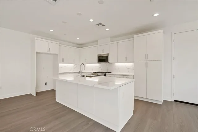 a kitchen with stainless steel appliances a sink stove and refrigerator