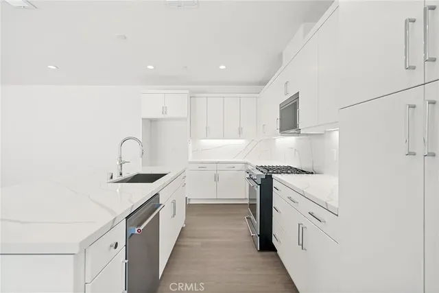 a kitchen with granite countertop white cabinets and white appliances