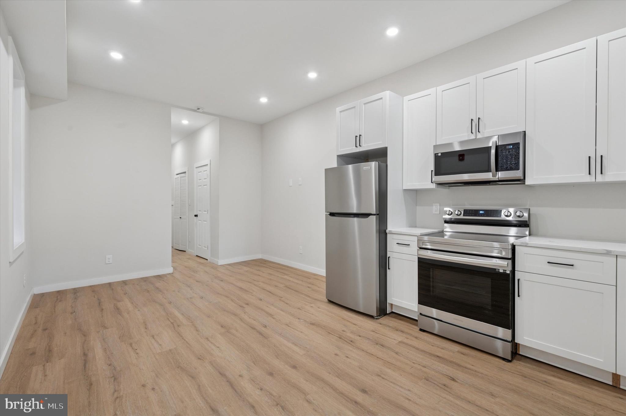 255 South 44th Street, Unit 1 Philadelphia, PA 19104 - Photo 11 of 26 a kitchen with granite countertop a refrigerator and a stove top oven