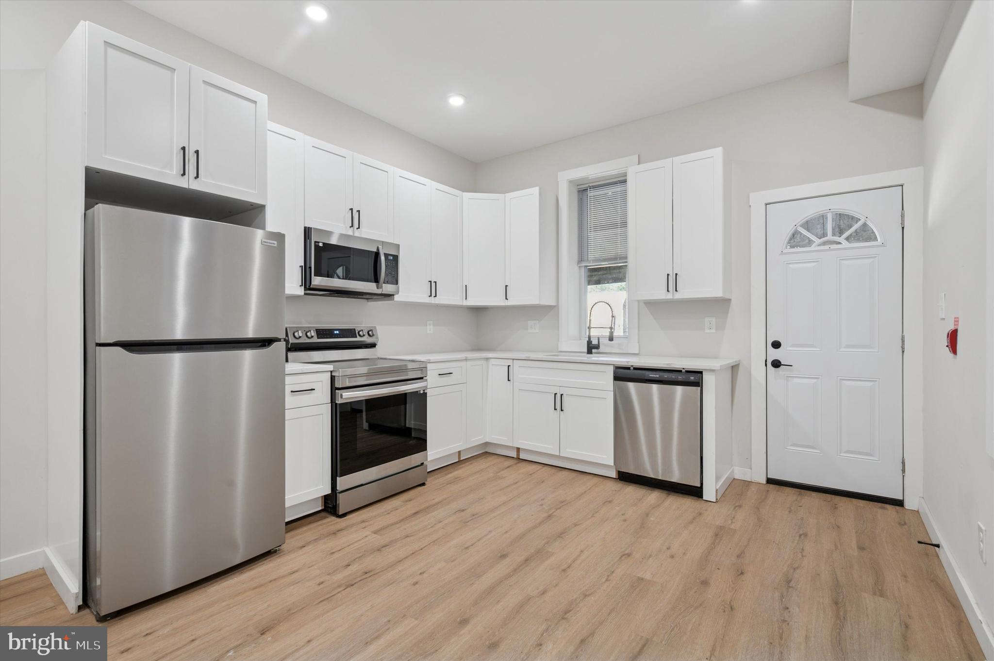 255 South 44th Street, Unit 1 Philadelphia, PA 19104 - Photo 5 of 26 a kitchen with a refrigerator stove and wooden cabinets