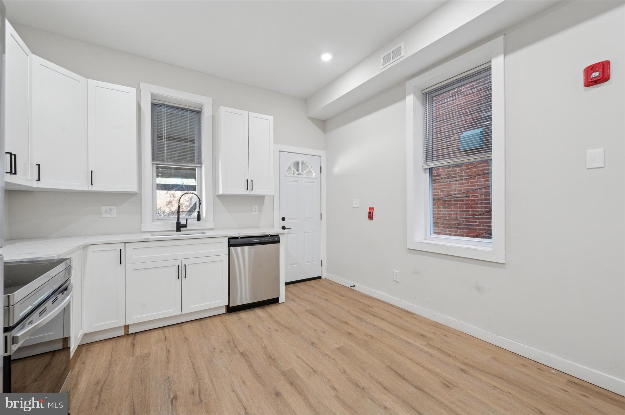 255 South 44th Street, Unit 1 Philadelphia, PA 19104 - Photo 8 of 26 a kitchen with granite countertop white cabinets and white appliances