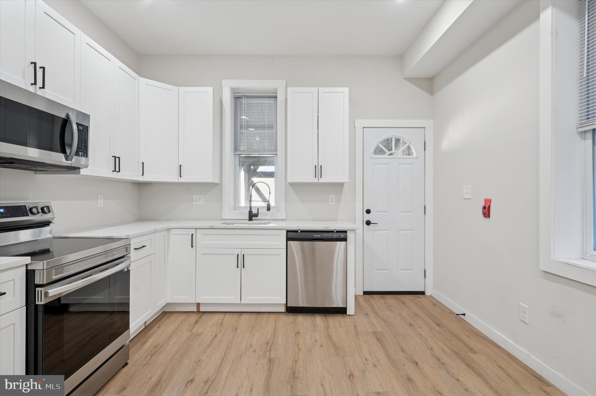 255 South 44th Street, Unit 1 Philadelphia, PA 19104 - Photo 9 of 26 a kitchen with granite countertop white cabinets stainless steel appliances and sink