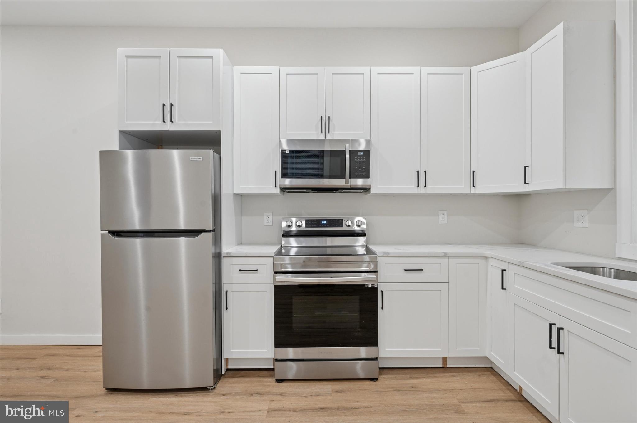 255 South 44th Street, Unit 1 Philadelphia, PA 19104 - Photo 10 of 26 a kitchen with stainless steel appliances white cabinets and a stove top oven