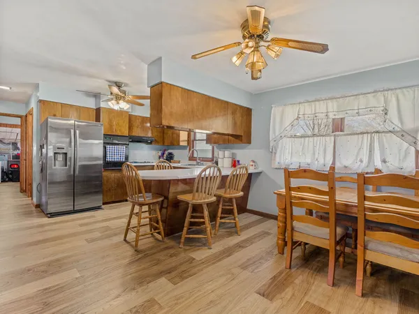 a dining room with furniture a chandelier and wooden floor