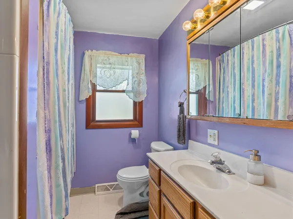 a bathroom with a sink vanity mirror and toilet
