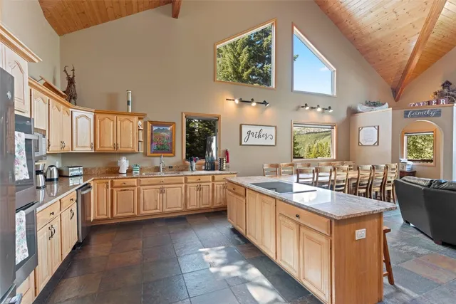 a large kitchen with stainless steel appliances granite countertop a lot of counter space and a sink