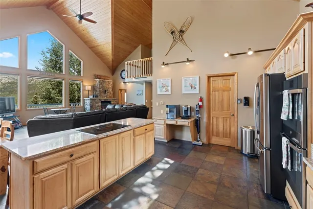 a large white kitchen with a large window and stainless steel appliances