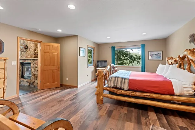 a spacious bedroom with a bed and wooden floor