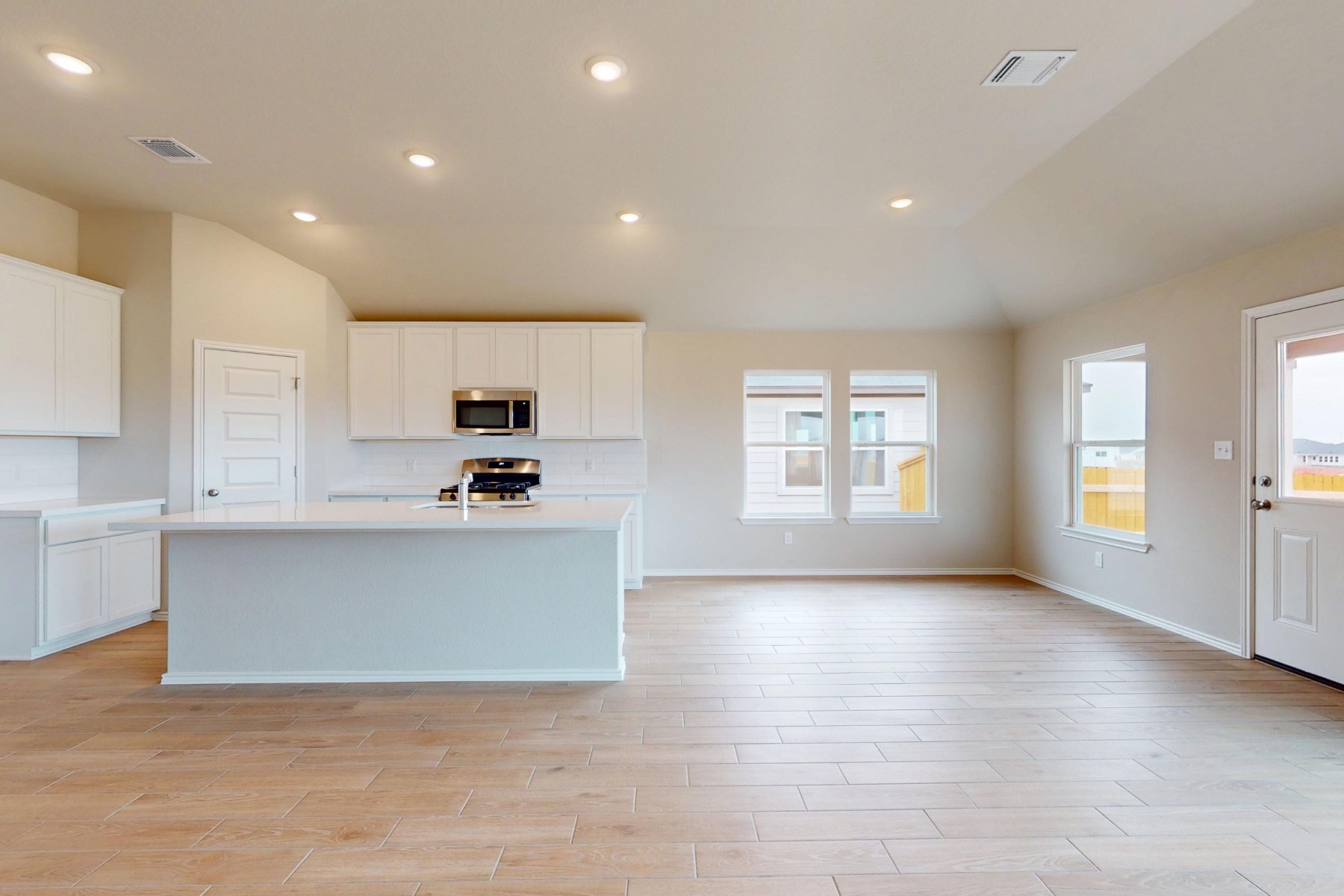 20009 Hirono Drive Manor, TX 78653 - Photo 4 of 39 a view of kitchen with kitchen island a sink wooden floor and a stove top oven