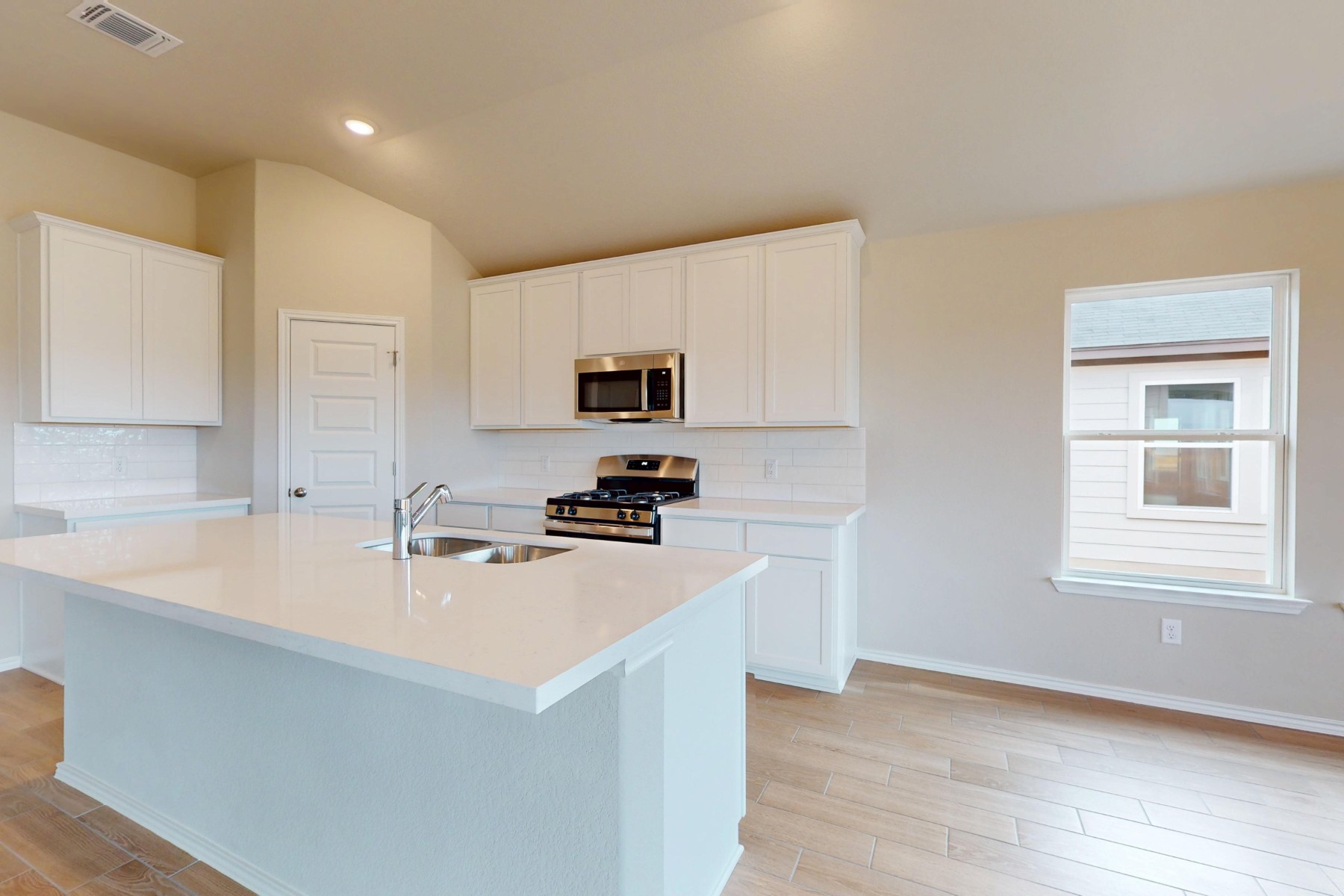 20009 Hirono Drive Manor, TX 78653 - Photo 5 of 39 a kitchen with a sink a stove a microwave and cabinets