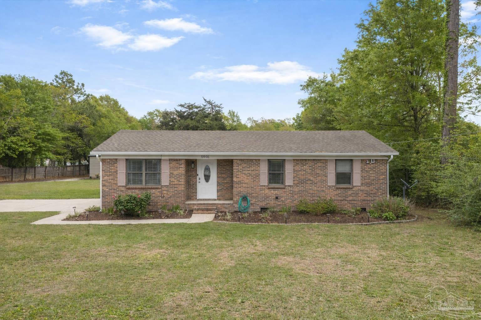 5946 Greenfield Street Pace, FL 32571 - Photo 1 of 42 a front view of house with yard and trees in the background
