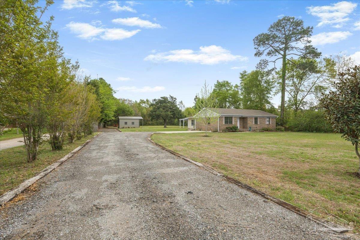 5946 Greenfield Street Pace, FL 32571 - Photo 14 of 42 a view of a house with backyard and trees