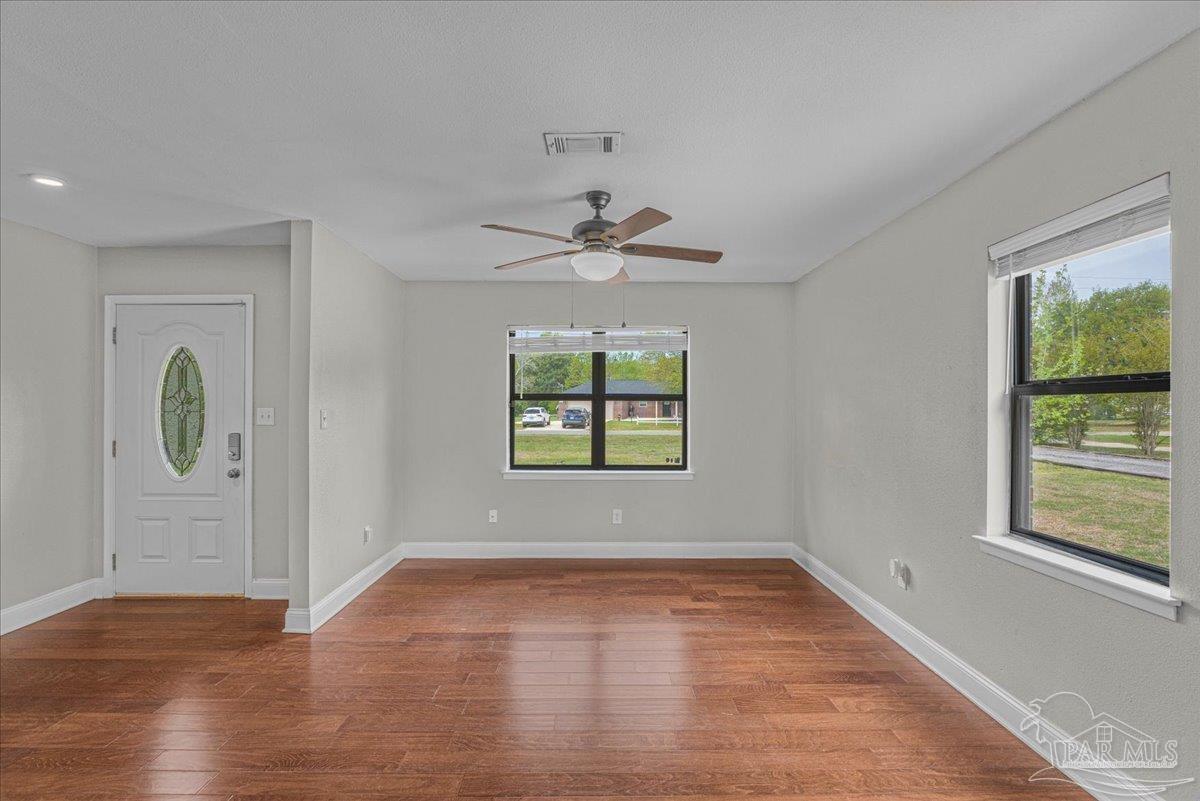 5946 Greenfield Street Pace, FL 32571 - Photo 17 of 42 wooden floor in an empty room with a window