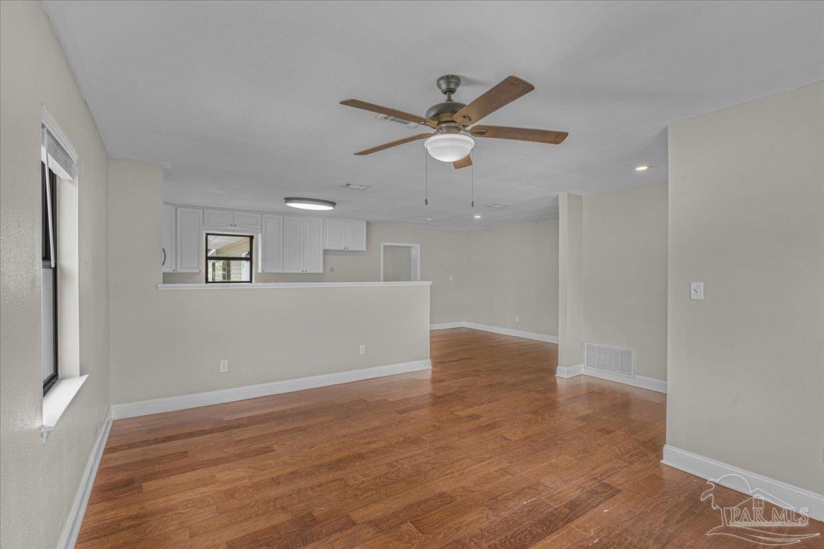 5946 Greenfield Street Pace, FL 32571 - Photo 19 of 42 a view of an empty room with wooden floor and a ceiling fan