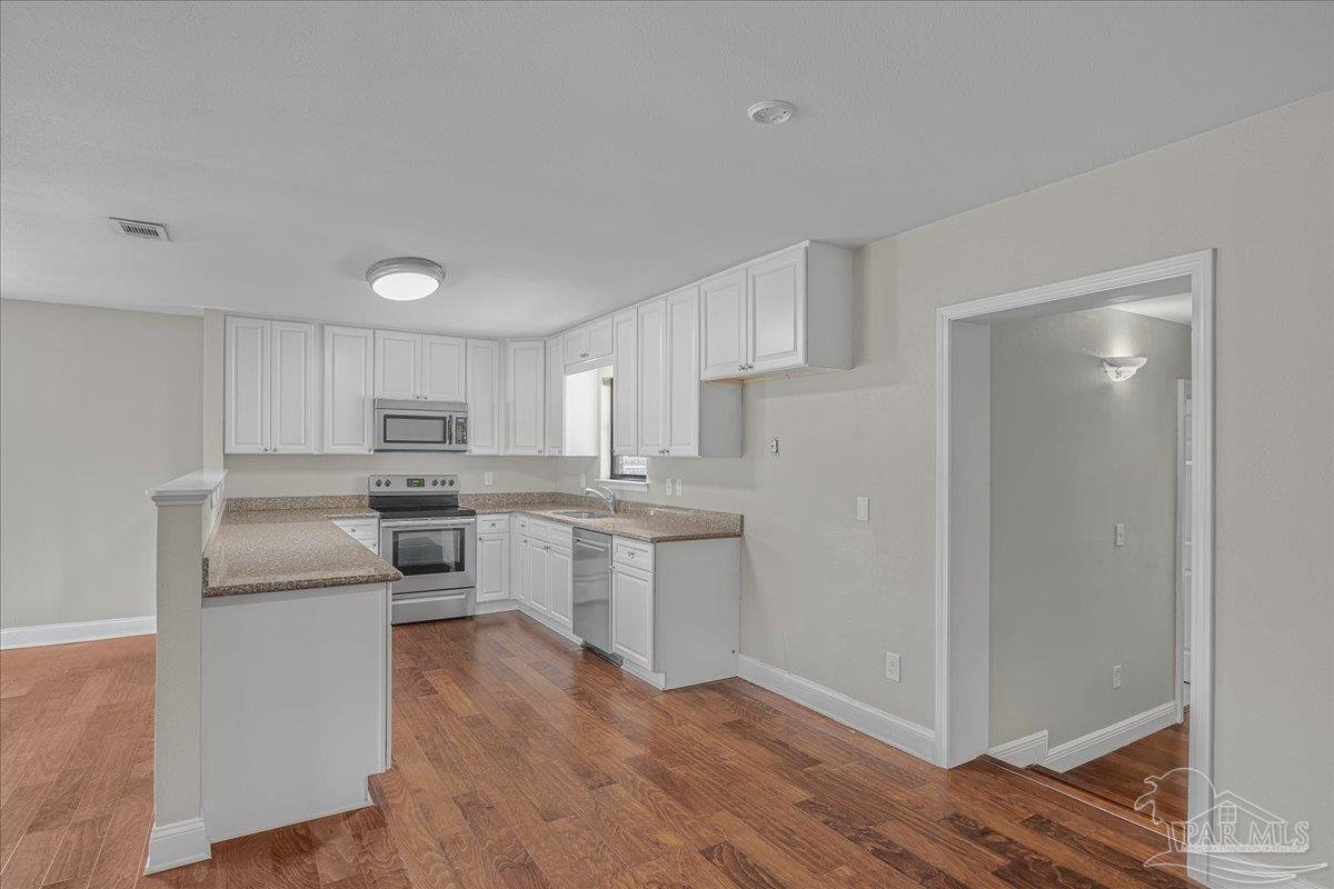 5946 Greenfield Street Pace, FL 32571 - Photo 22 of 42 a kitchen with white cabinets and white appliances