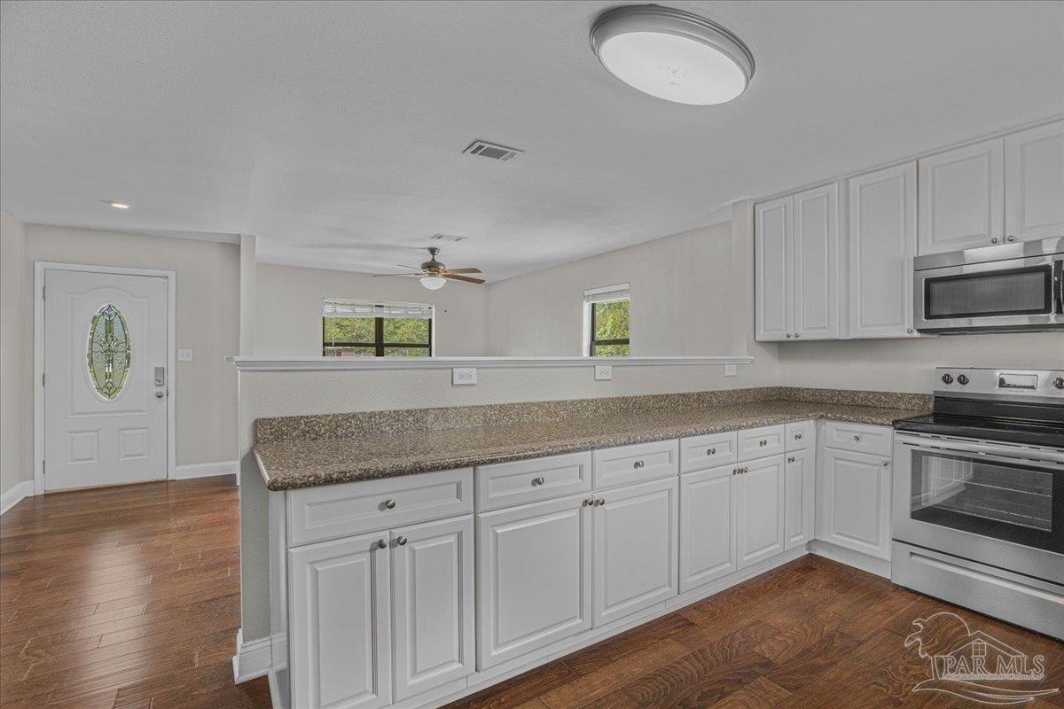 5946 Greenfield Street Pace, FL 32571 - Photo 23 of 42 a kitchen with granite countertop white cabinets and a sink