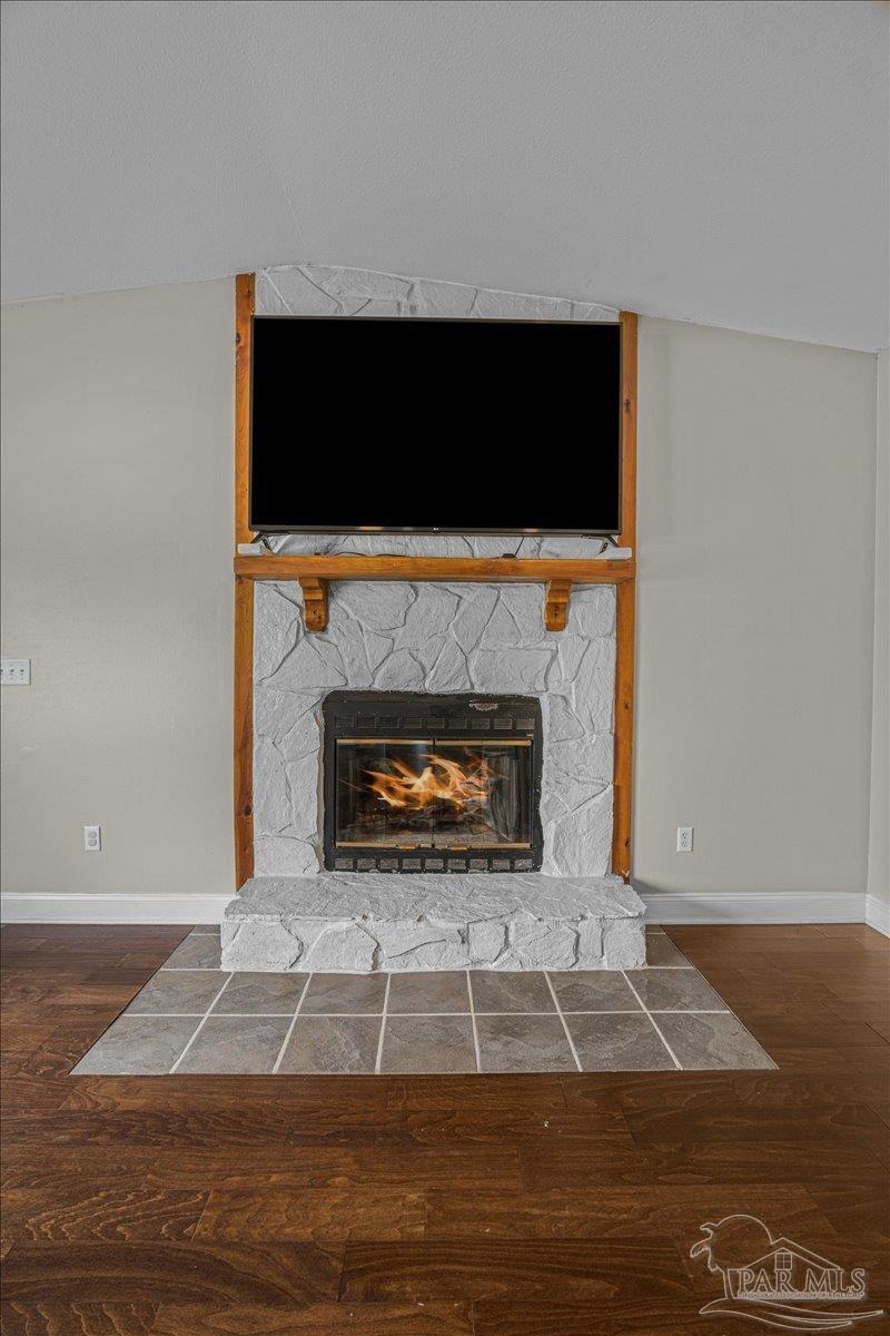 5946 Greenfield Street Pace, FL 32571 - Photo 25 of 42 a living room with a fireplace and a flat screen tv