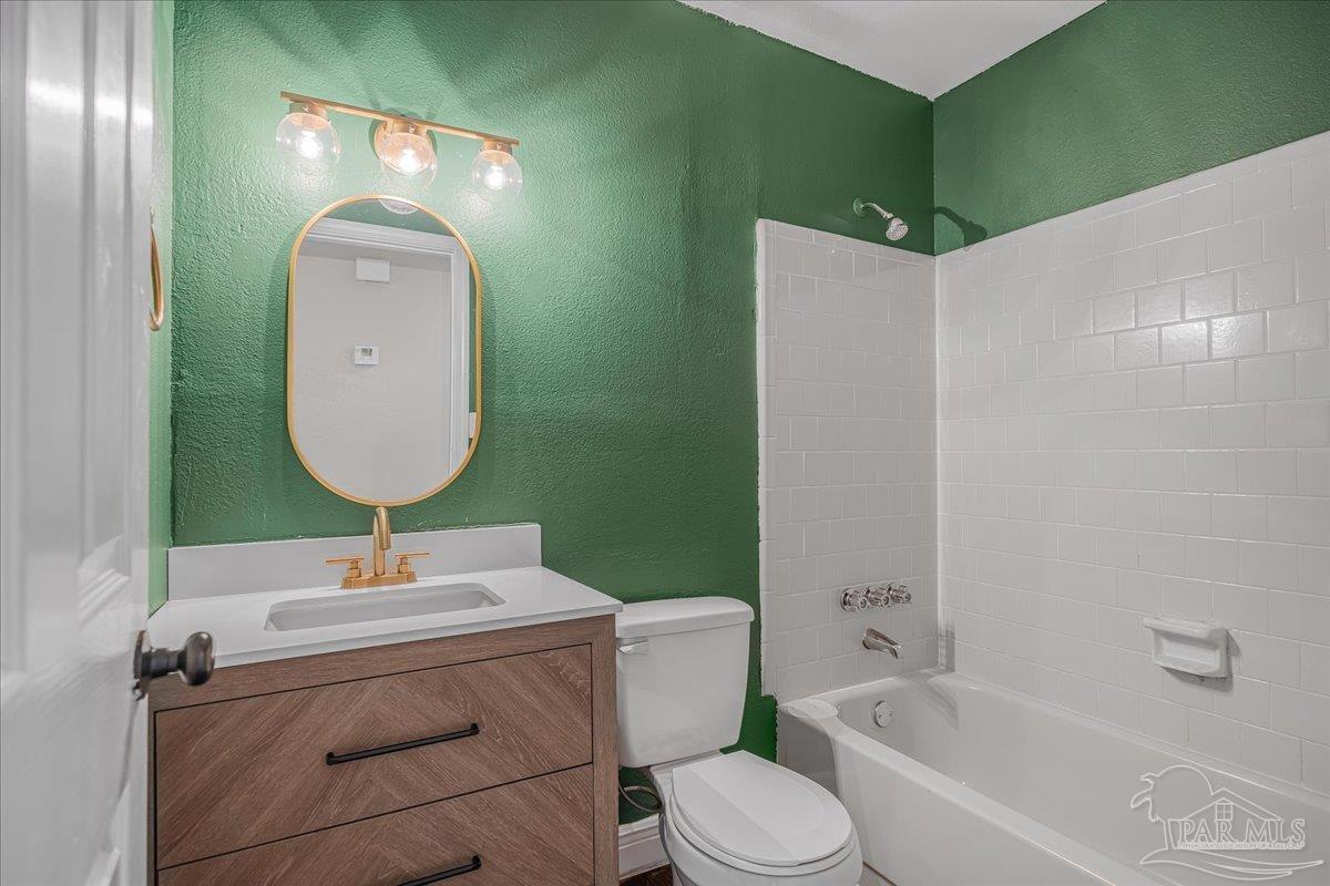 5946 Greenfield Street Pace, FL 32571 - Photo 29 of 42 a bathroom with a toilet sink and mirror