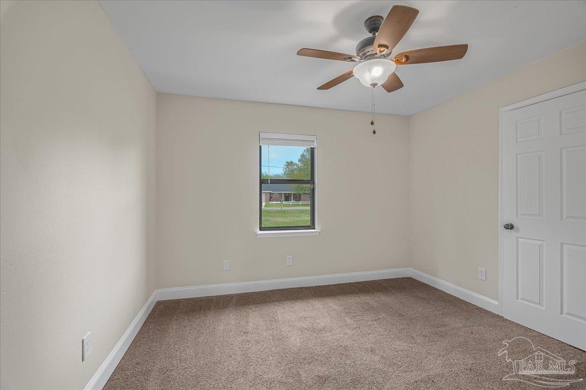 5946 Greenfield Street Pace, FL 32571 - Photo 30 of 42 an empty room with a window and a fan