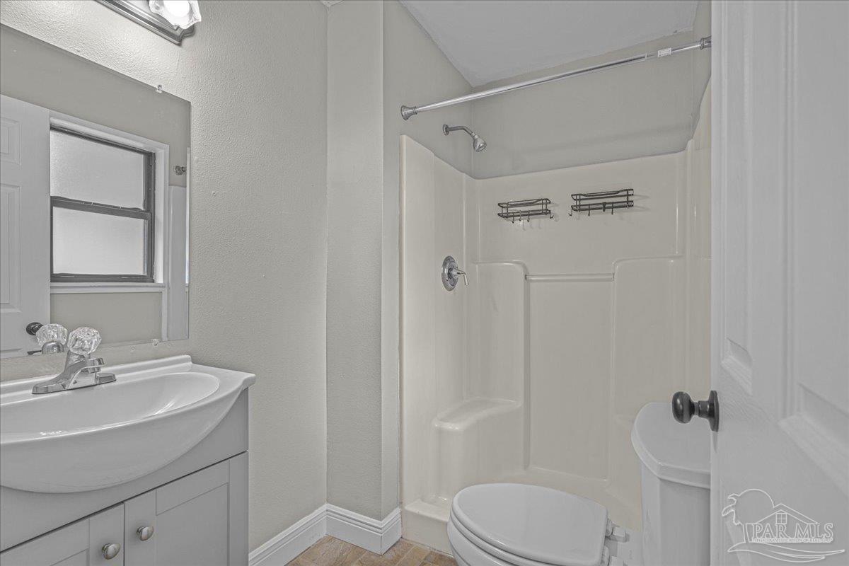 5946 Greenfield Street Pace, FL 32571 - Photo 35 of 42 a bathroom with a sink toilet and shower