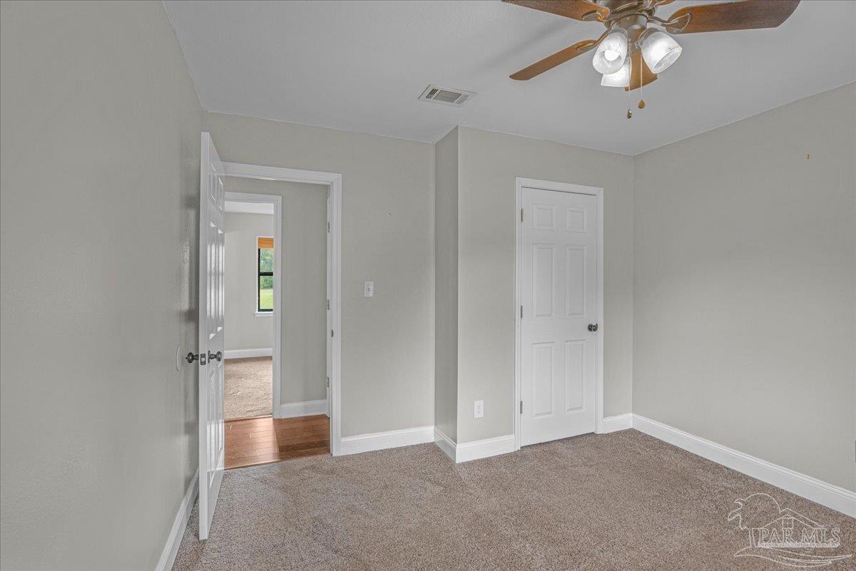 5946 Greenfield Street Pace, FL 32571 - Photo 37 of 42 an empty room with chandelier fan and closet area
