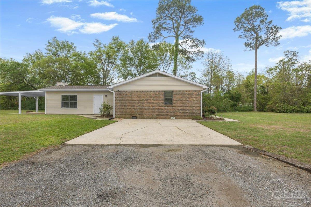 5946 Greenfield Street Pace, FL 32571 - Photo 39 of 42 a front view of a house with garden