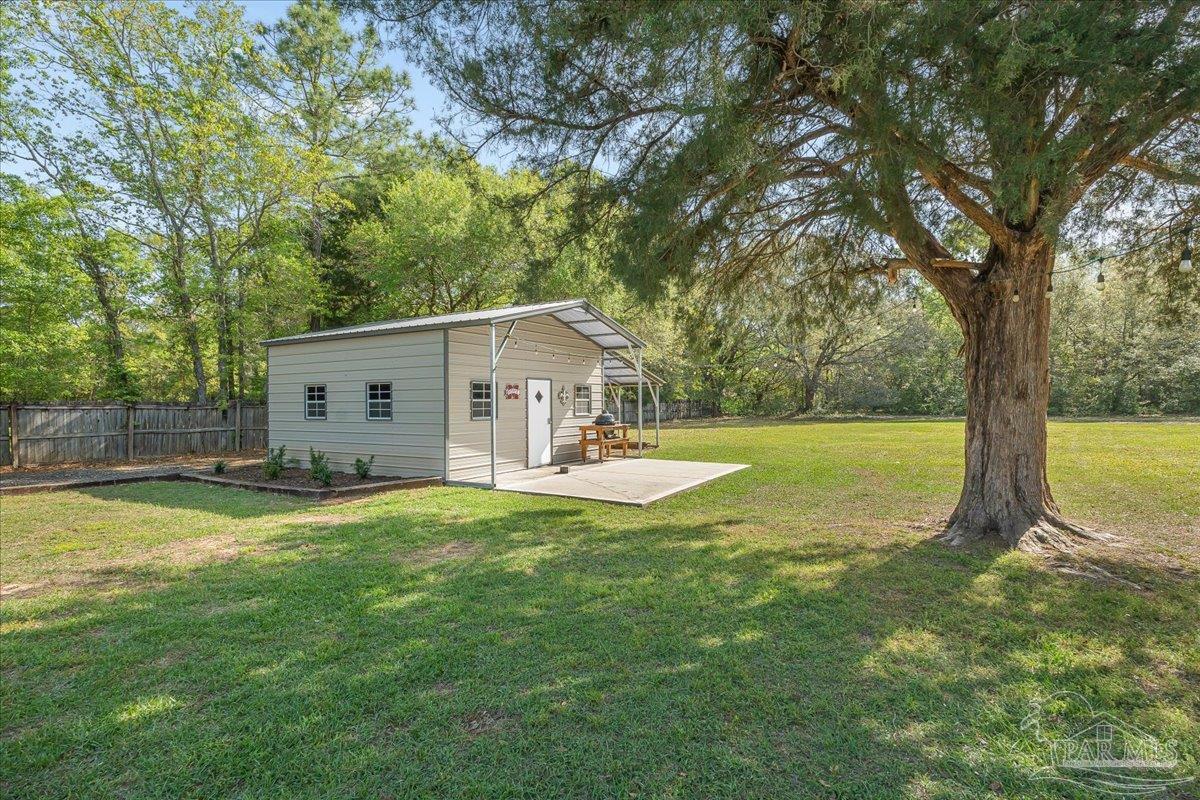 5946 Greenfield Street Pace, FL 32571 - Photo 7 of 42 a view of a house with swimming pool and a yard