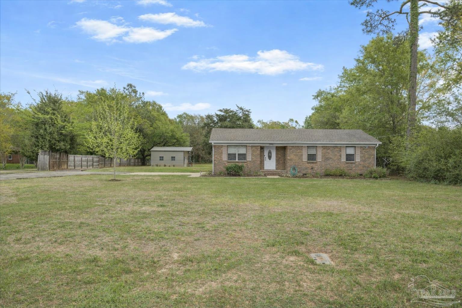 5946 Greenfield Street Pace, FL 32571 - Photo 9 of 42 a front view of a house with a garden