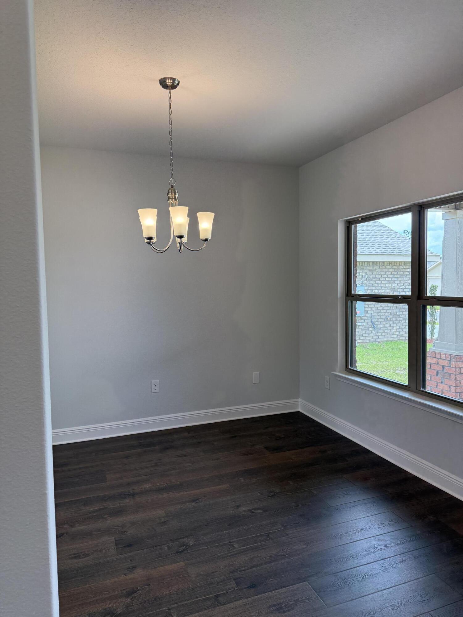 185 Ridgeway Circle Crestview, FL 32536 - Photo 5 of 30 a view of a room with wooden floor chandelier and windows