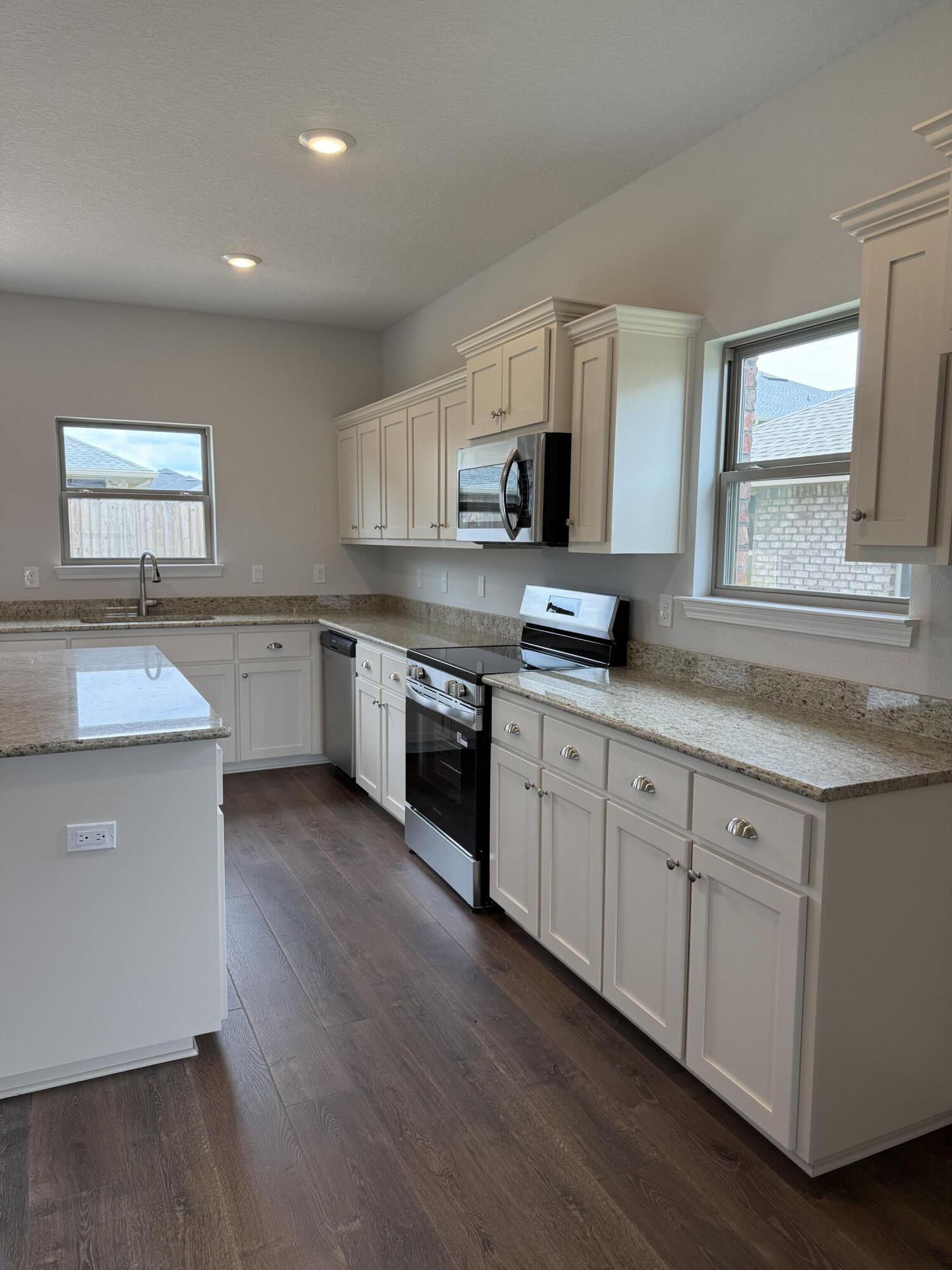 185 Ridgeway Circle Crestview, FL 32536 - Photo 8 of 30 a kitchen with granite countertop white cabinets and white stainless steel appliances