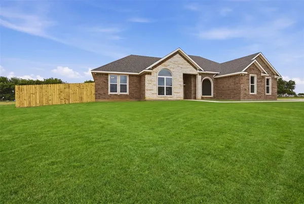 a front view of a house with yard and green space