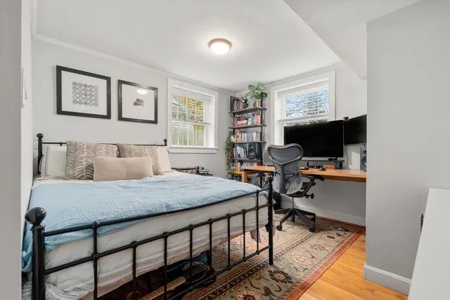 a bedroom that has a bed and a table in it with wooden floor