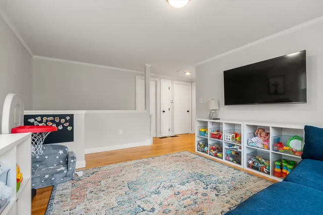 a view of a livingroom with wooden floor and a flat screen tv