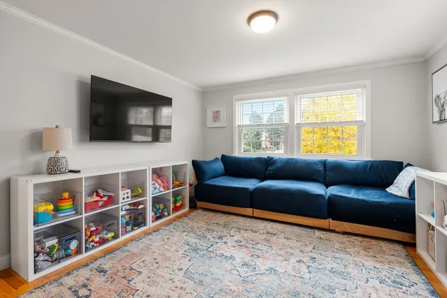 a living room with furniture a flat screen tv and a window