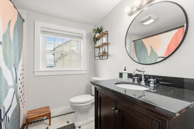 a bathroom with a granite countertop sink mirror and toilet