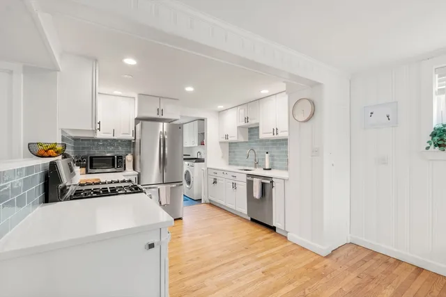 a kitchen with white cabinets and stainless steel appliances