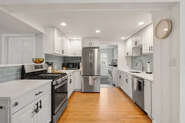 a kitchen with white cabinets and stainless steel appliances
