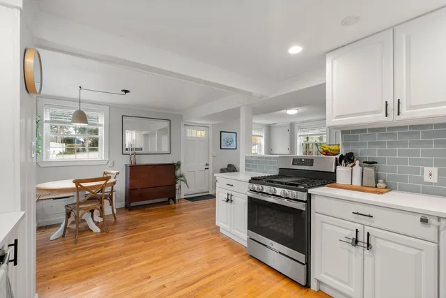 a kitchen with granite countertop a stove a sink a counter space and cabinets