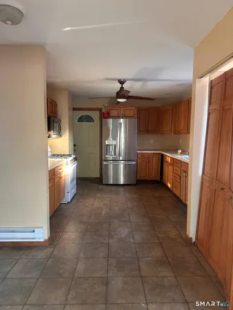 a kitchen with stainless steel appliances granite countertop a refrigerator and a stove top oven