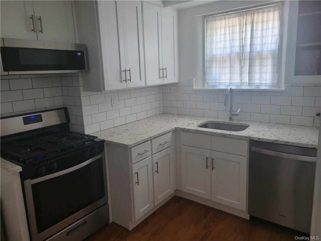 a kitchen with white cabinets appliances and sink