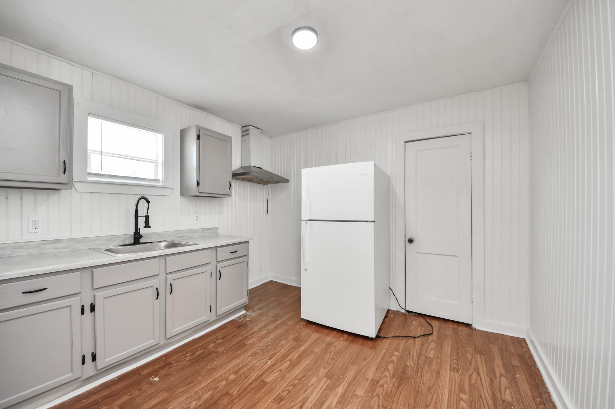 3804 Lila Street Houston, TX 77026 - Photo 6 of 16 a kitchen with sink cabinets and wooden floor
