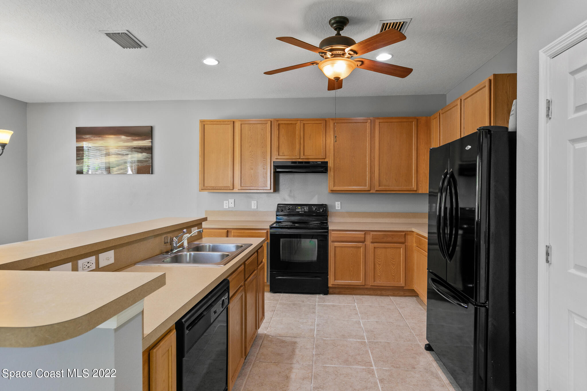1963 Jupiter Boulevard Southwest Palm Bay, FL 32908 - Photo 13 of 42 a kitchen with a stove a refrigerator and a sink