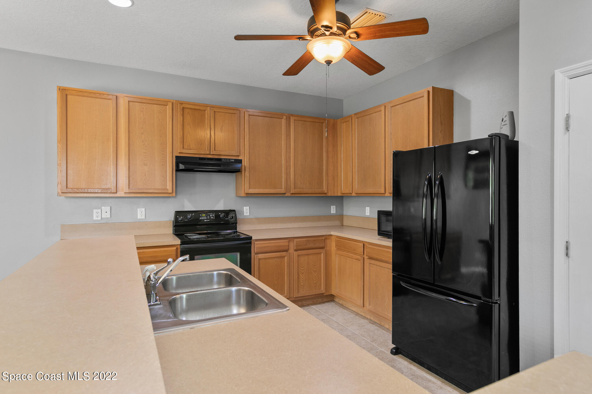 1963 Jupiter Boulevard Southwest Palm Bay, FL 32908 - Photo 14 of 42 a kitchen with a refrigerator sink and cabinets