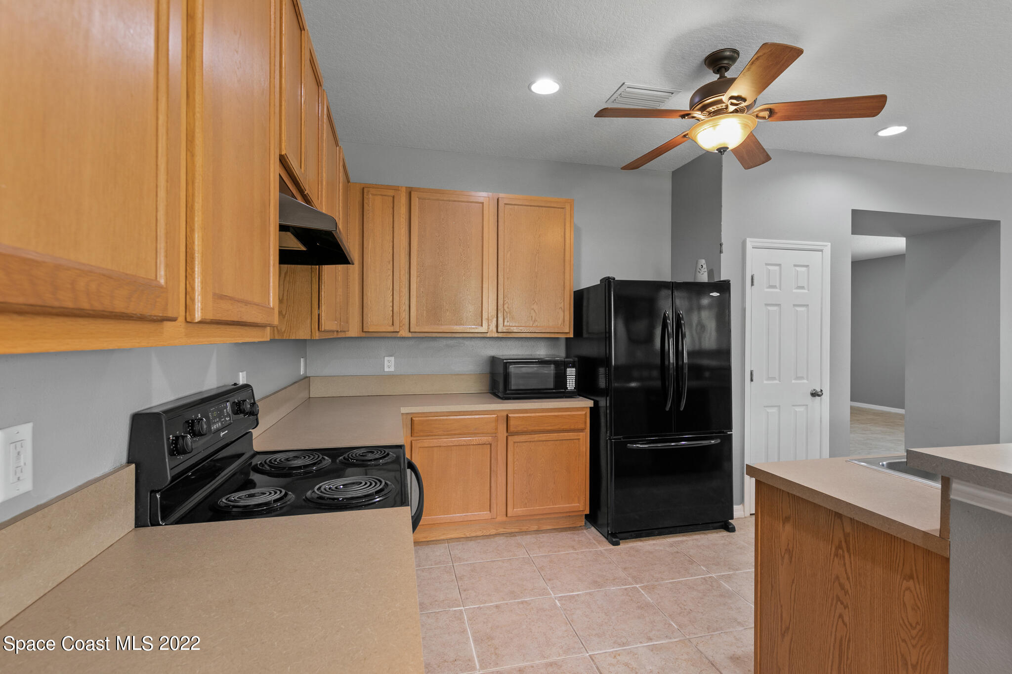 1963 Jupiter Boulevard Southwest Palm Bay, FL 32908 - Photo 15 of 42 a kitchen with a refrigerator a stove top oven a sink and dishwasher