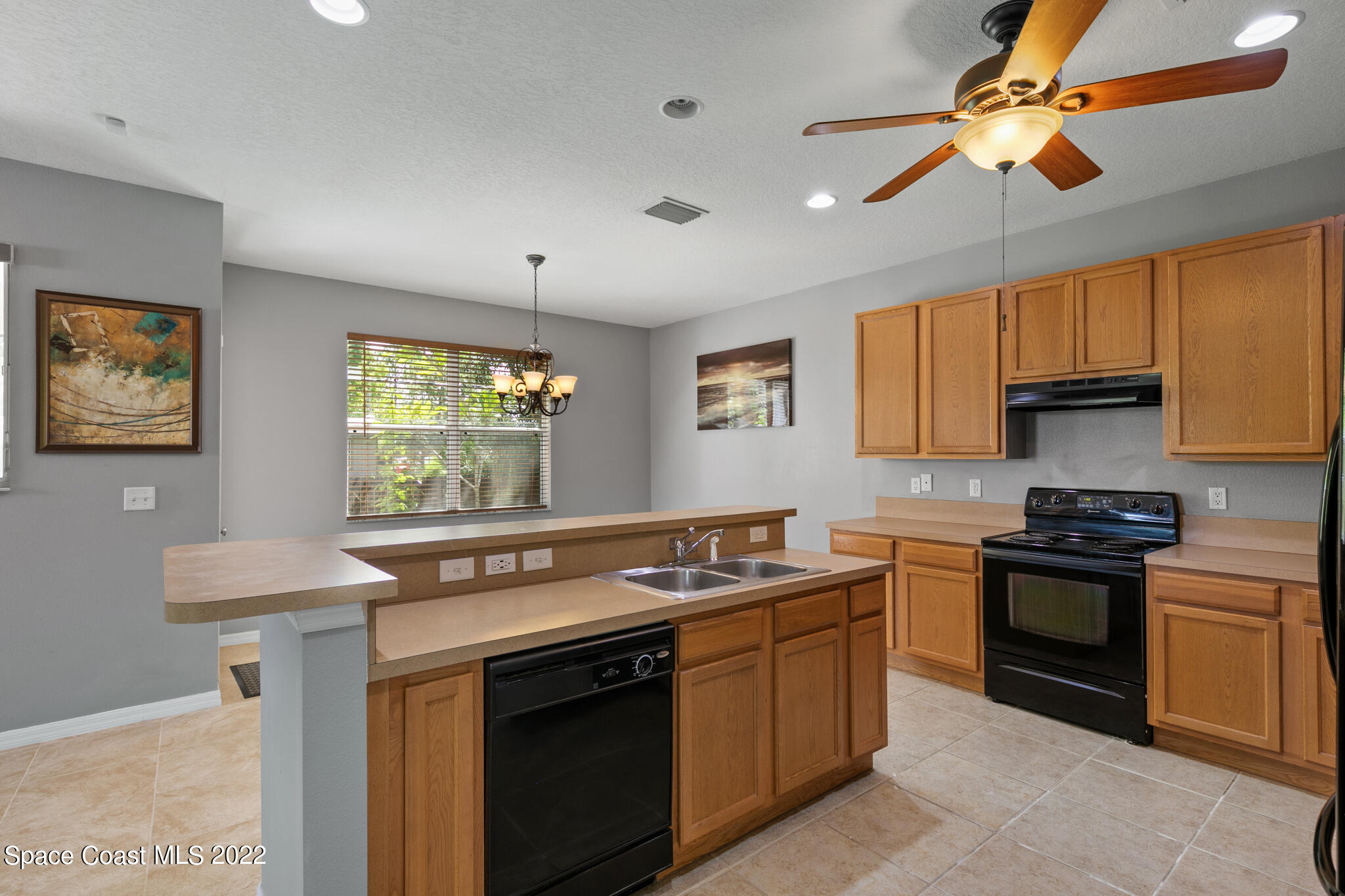1963 Jupiter Boulevard Southwest Palm Bay, FL 32908 - Photo 17 of 42 a kitchen with stainless steel appliances granite countertop a stove sink and microwave