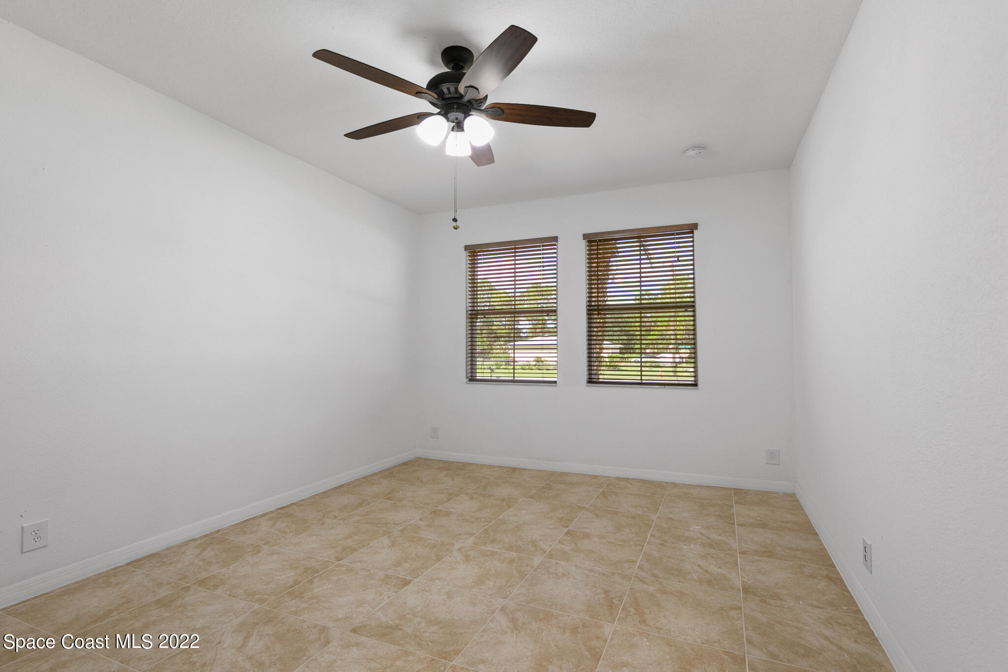 1963 Jupiter Boulevard Southwest Palm Bay, FL 32908 - Photo 21 of 42 an empty room with ceiling fan and windows