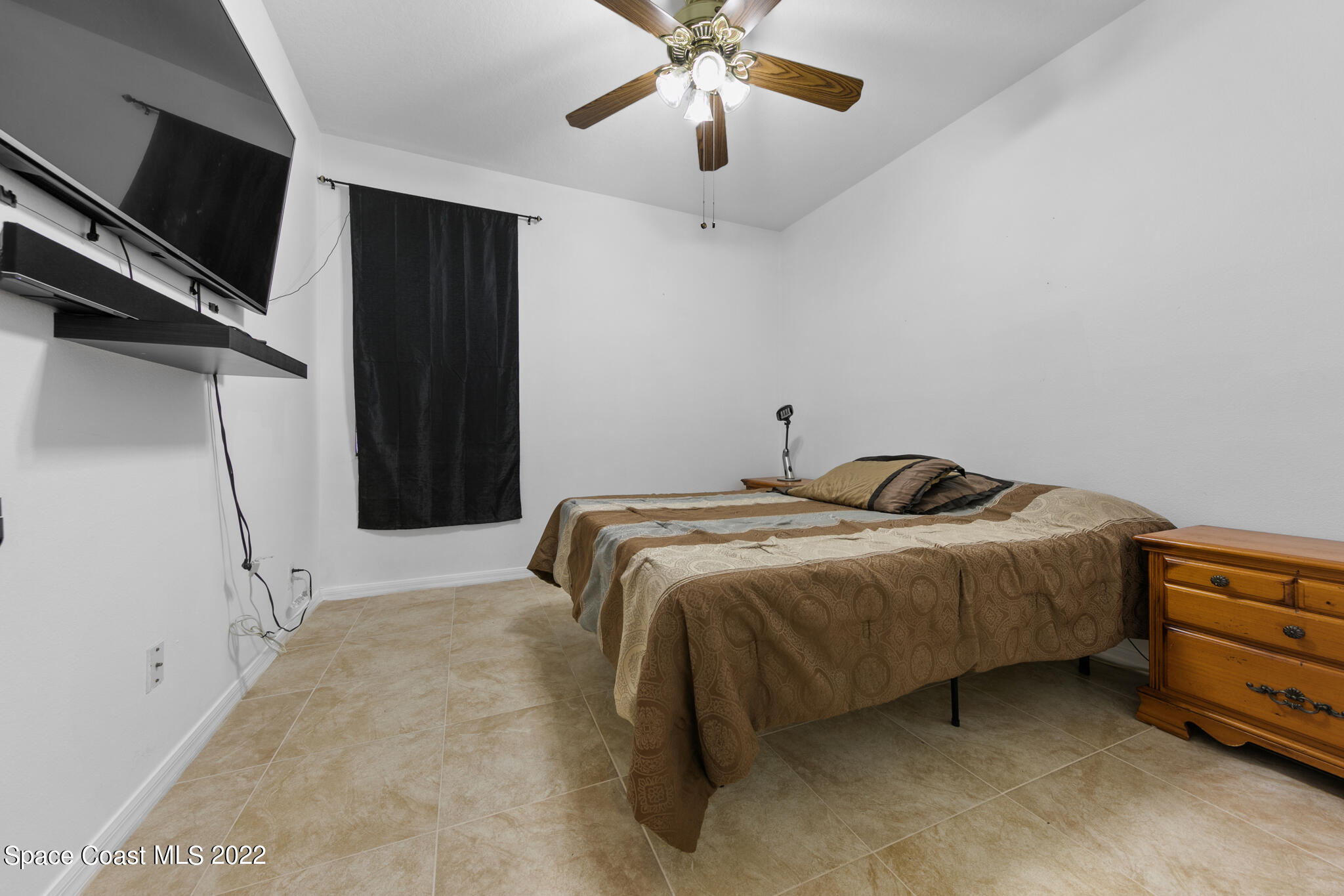 1963 Jupiter Boulevard Southwest Palm Bay, FL 32908 - Photo 26 of 42 a bedroom with a bed and a ceiling fan