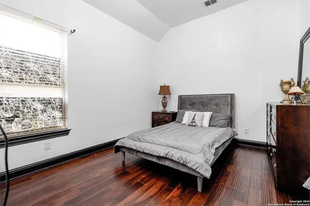 a bedroom with a bed and wooden floor