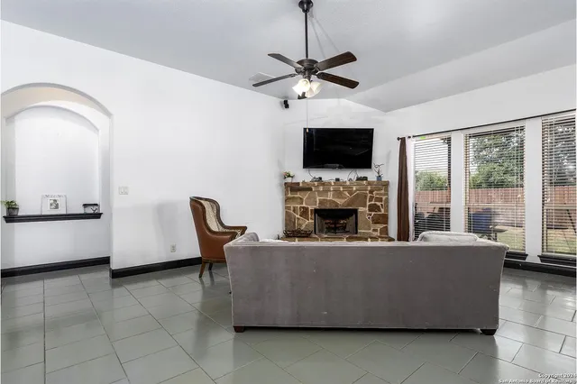 a living room with furniture a fireplace and a flat screen tv
